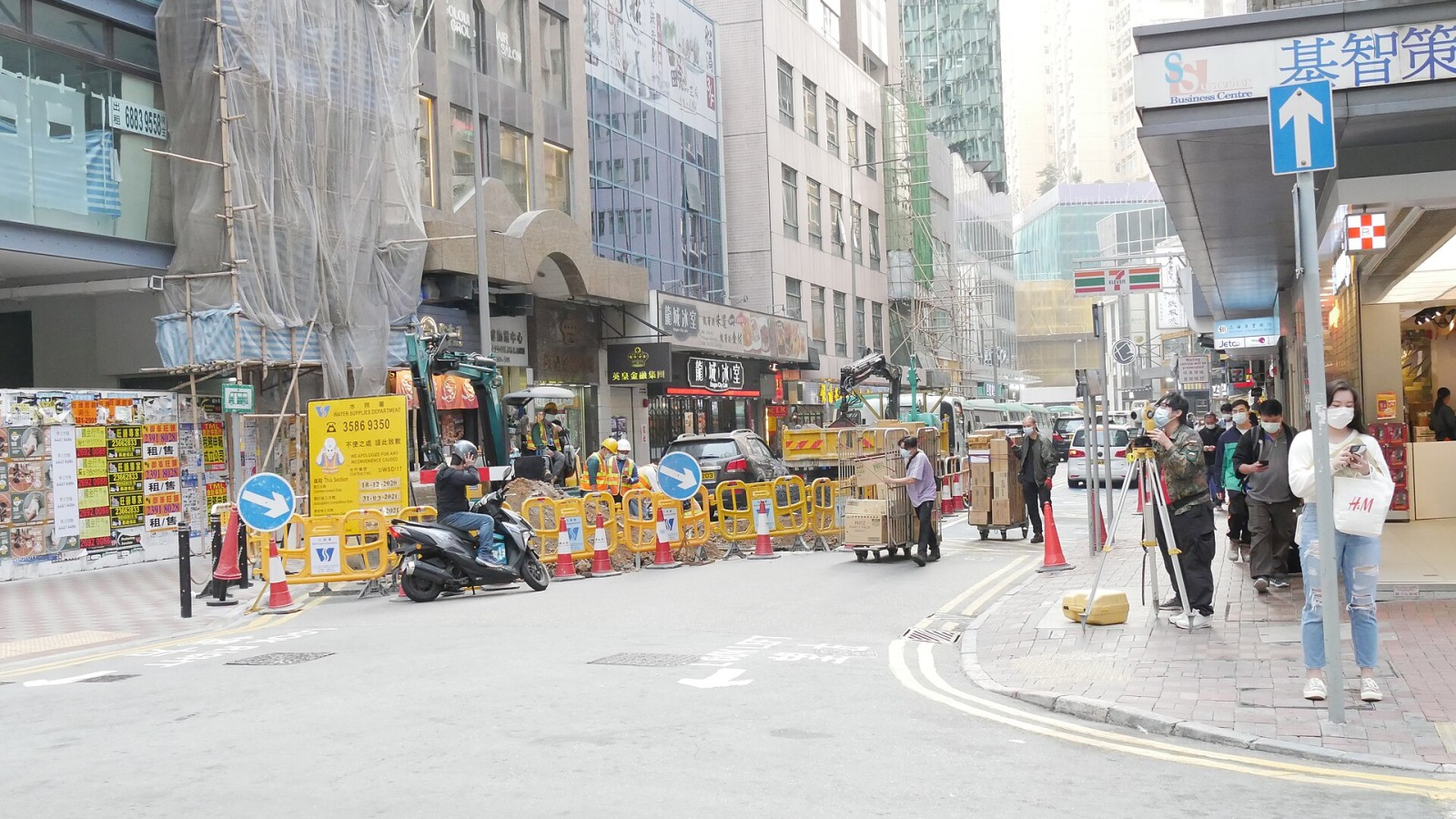 In a construction site on the streets of Causeway Bay, Some construction workerare working hard, and some construction workers are surveying their work