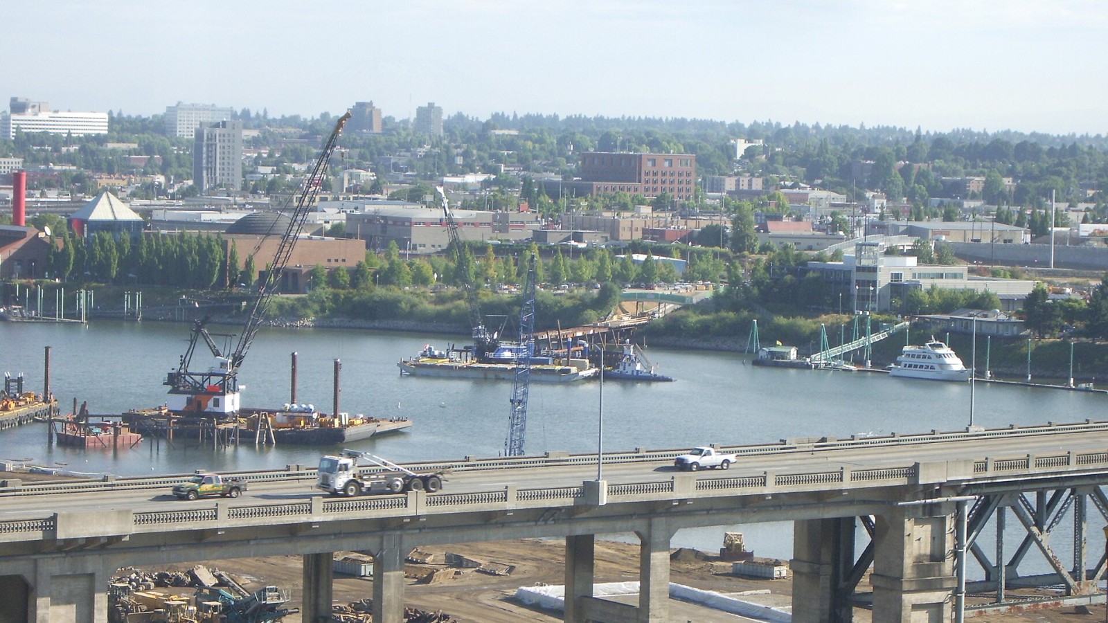 The en:Portland-Milwaukie Light Rail Bridge construction site captured about 30 days after construction began. OMSI is at left and the Ross Island Bridge is in foreground. View is from OHSU center for health and healing