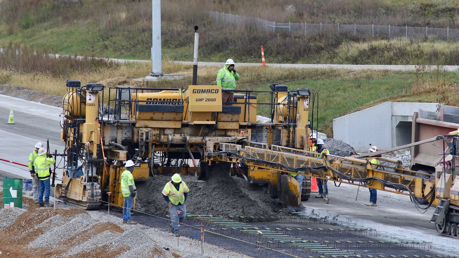 A Gomaco GHP-2800 paver in use for the Indiana I-69 Corridor Project, Section 6 (Morgan/Johnson/Marion counties). This photo shows workers paving a strip of concrete for the northbound lanes of I-69 just north of the Sta