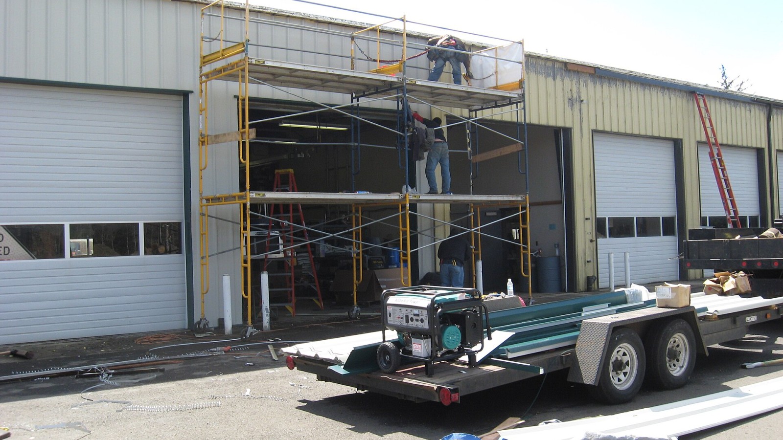 Workers from Weatherguard Inc. fix the roof and replace siding and doors on an Oregon Department of Transportation building in Warrenton. The project was funded through Go Oregon stimulus funds.