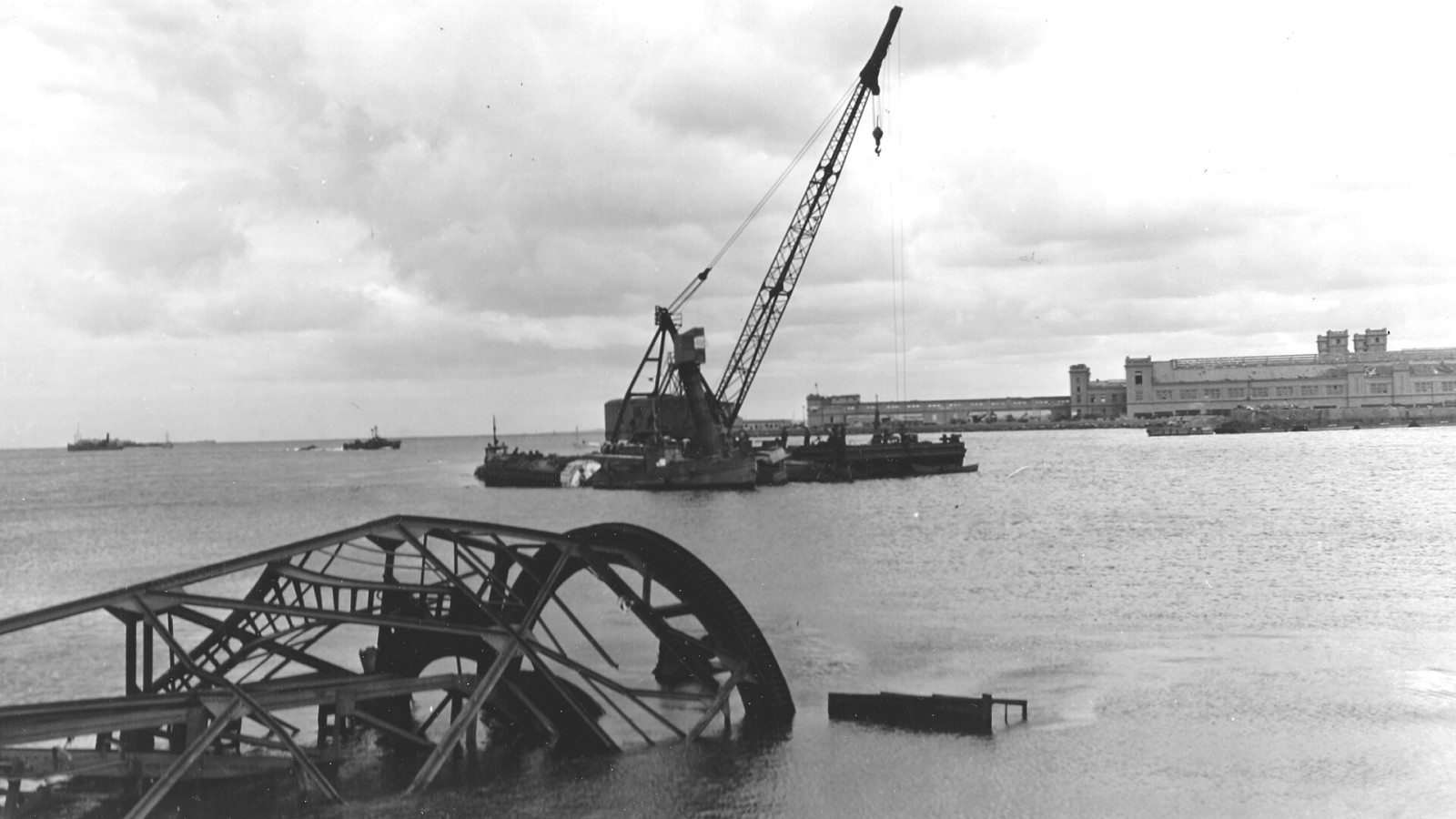 Dans le port de Cherbourg une grue à flèche sur une plateforme, travaux de remise en état après les destructions faites par les allemands. Les travaux sont sous la responsabilité du 1056th Engineer Port Construction & Re