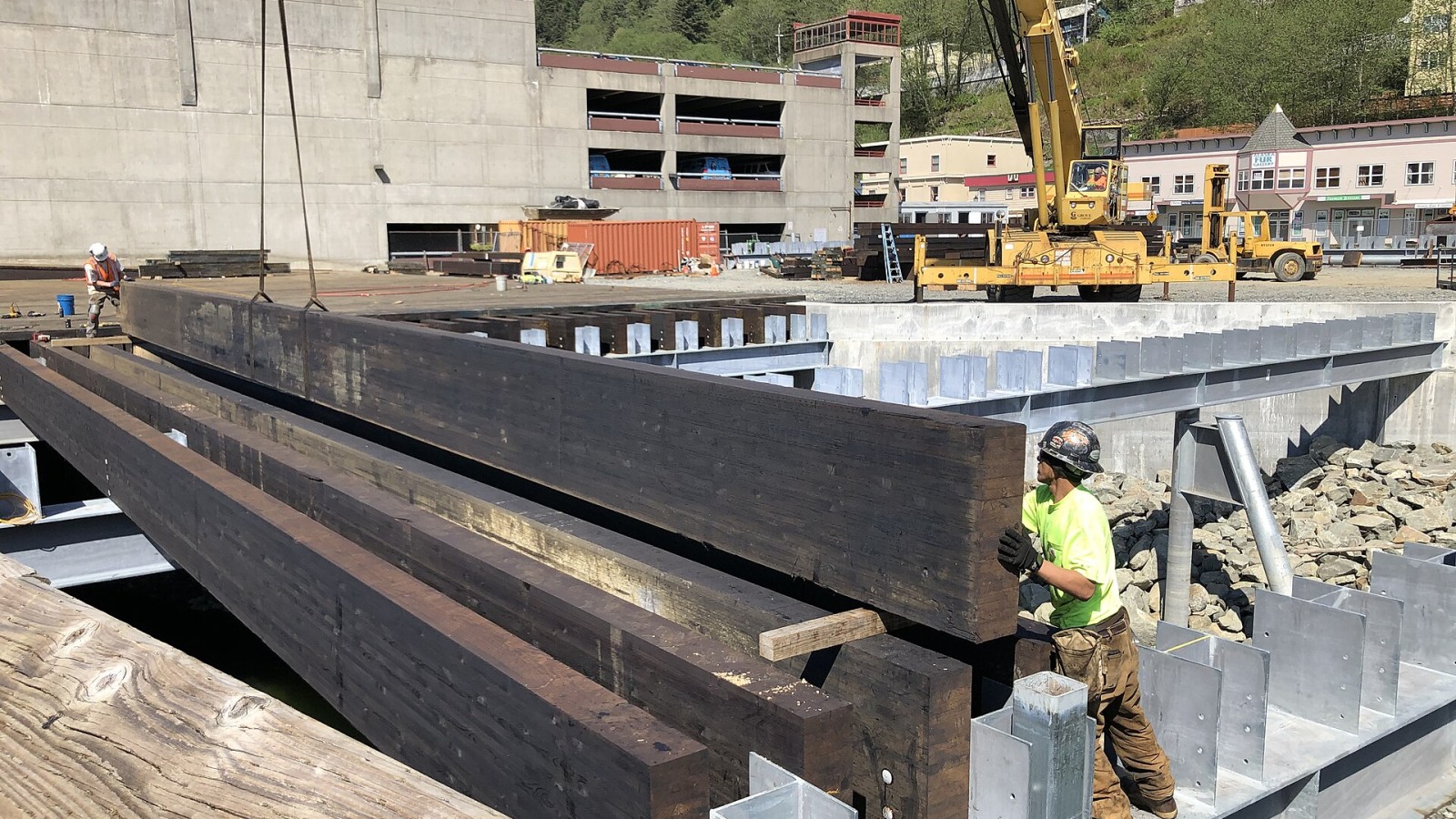 A worker guides wooden beams into place May 11, 2020 at the Archipelago Property on the Juneau, Alaska waterfront. The Archipelago development is intended to expand the number of tourism-oriented retail shops in Juneau.