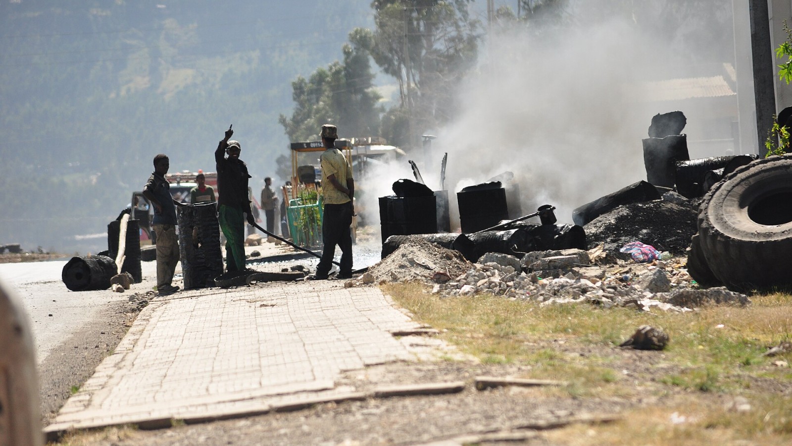 Road construction workers laying out asphalt