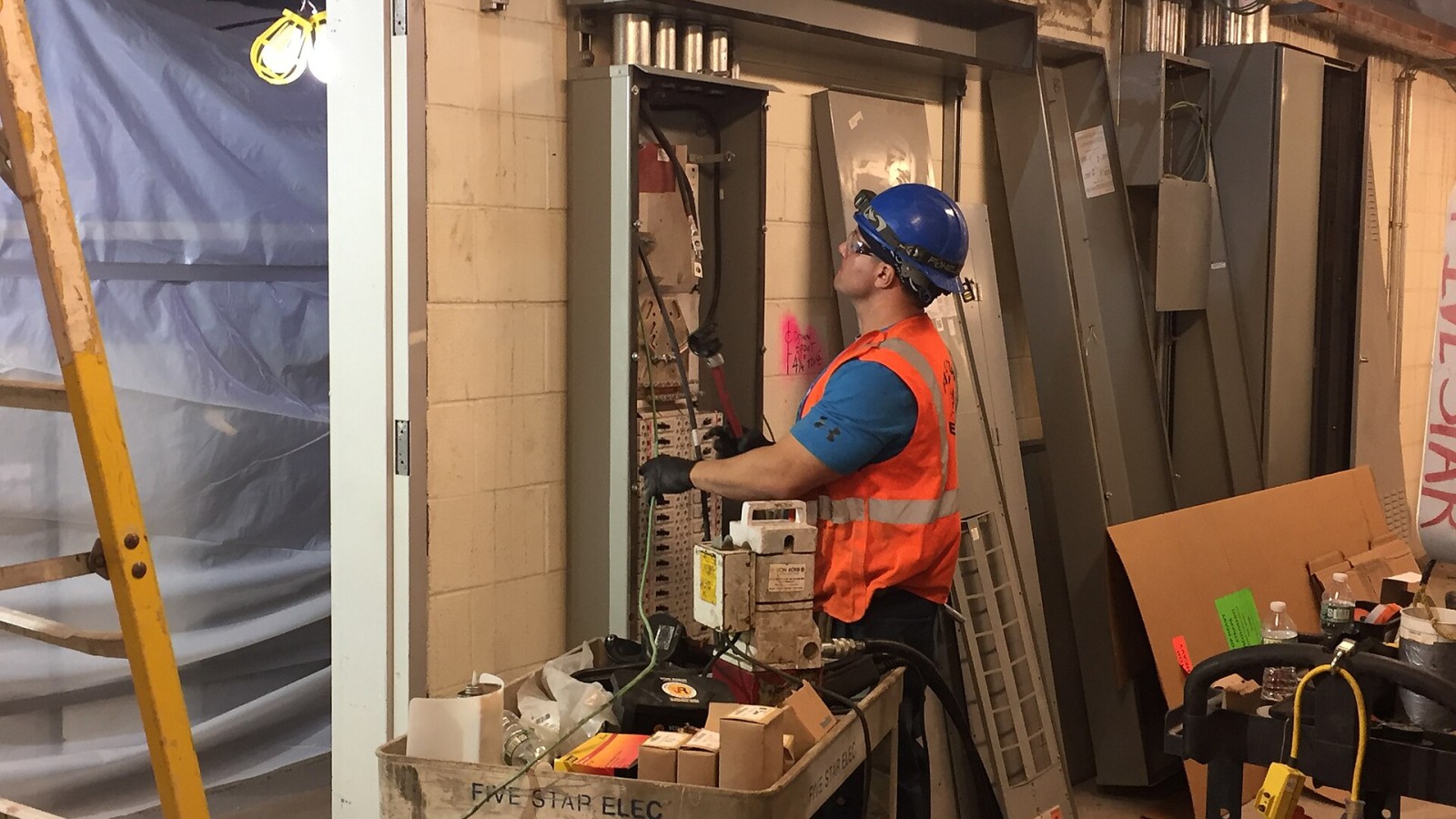 Electrician pulling wires to an electrical panel in a substation room located in the back of house area of the concourse. (CM014B, 11-14-2018)