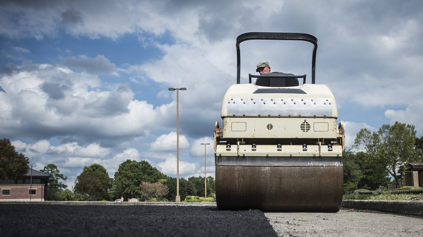Staff Sgt. John Hedges, 628th Civil Engineer Squadron horizontal construction worker, flattens a section of new asphalt with a steam roller during a re-pavement job Sept. 10, 2014, at Joint Base Charleston, S.C. RED HORS