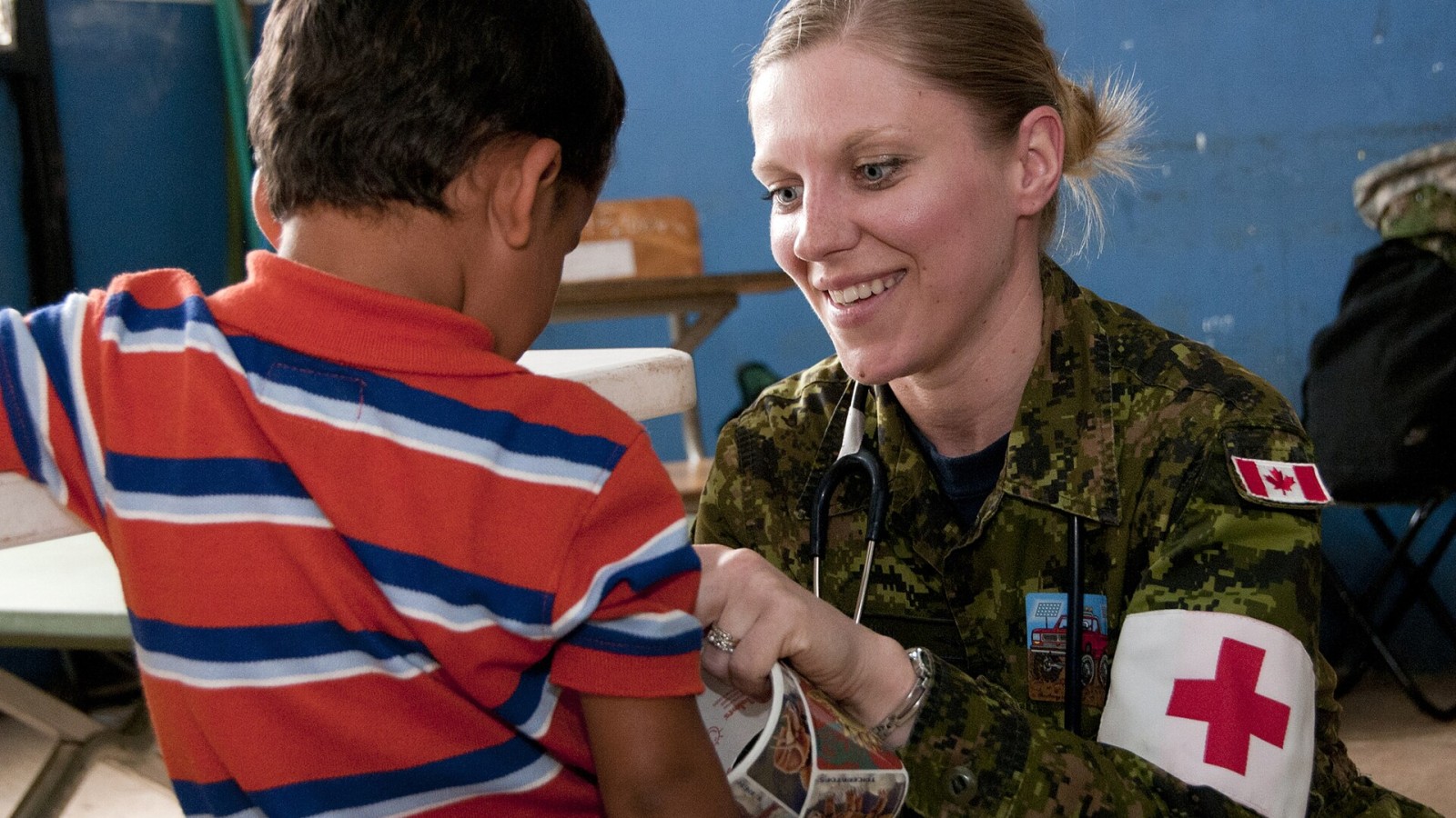 Canadian Forces Capt. Karoline Martin, a nurse with the Canadian Forces Health Services Center, gives a child a sticker after an examination during a medical clinic April 15, 2013, in Caluco, El Salvador, as part of Beyo