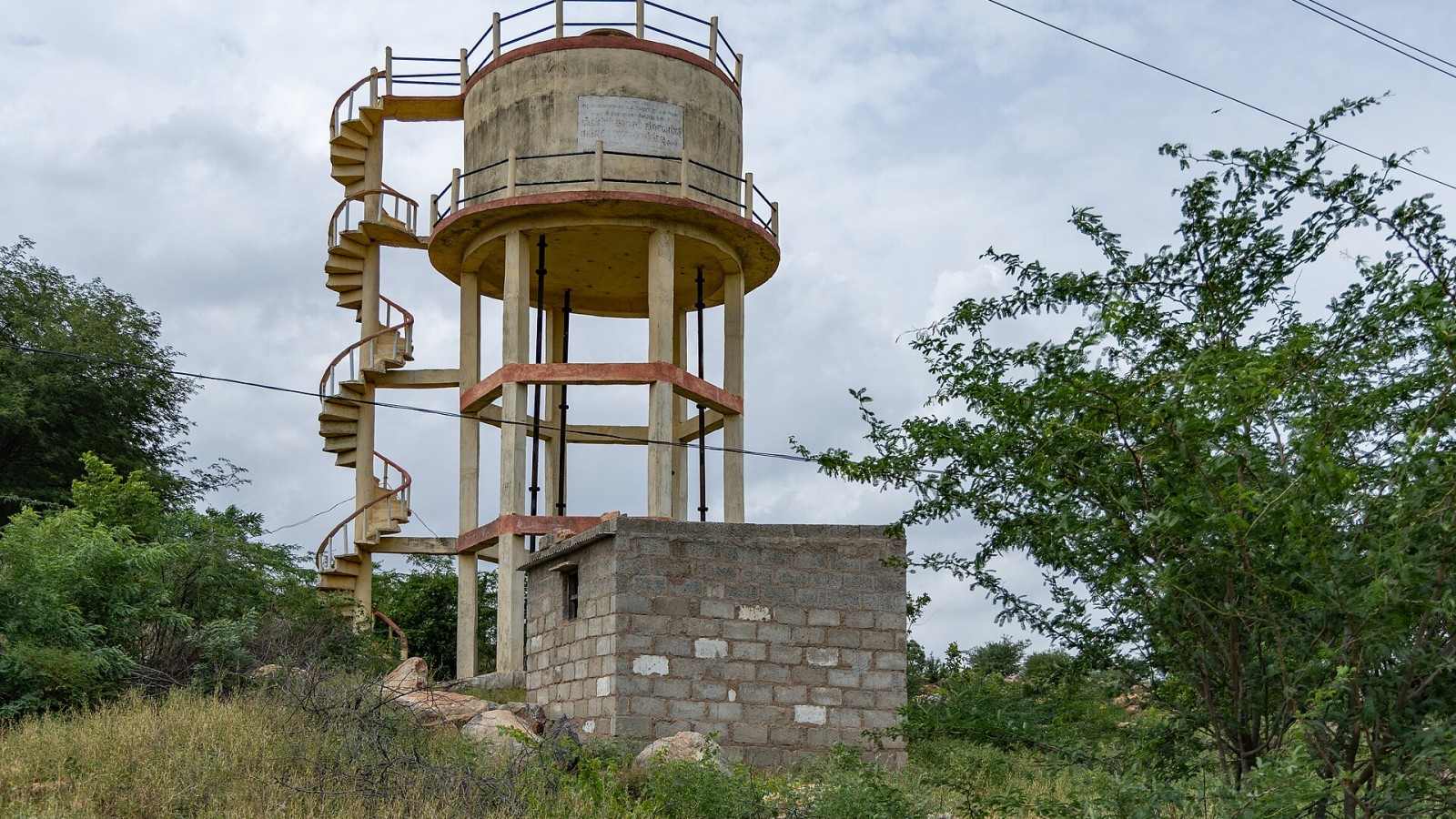 Overhead water tank in Raichur district, Karnataka, India, used for rural water supply and storage. The structure consists of an elevated reinforced concrete tank supported on columns, with a spiral staircase for access.
