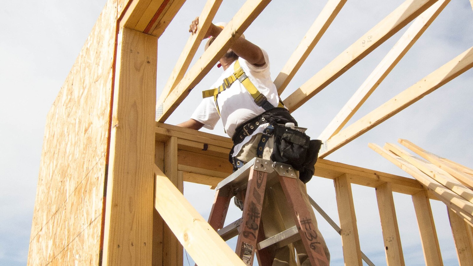 A residential construction worker uses a fall arrest system