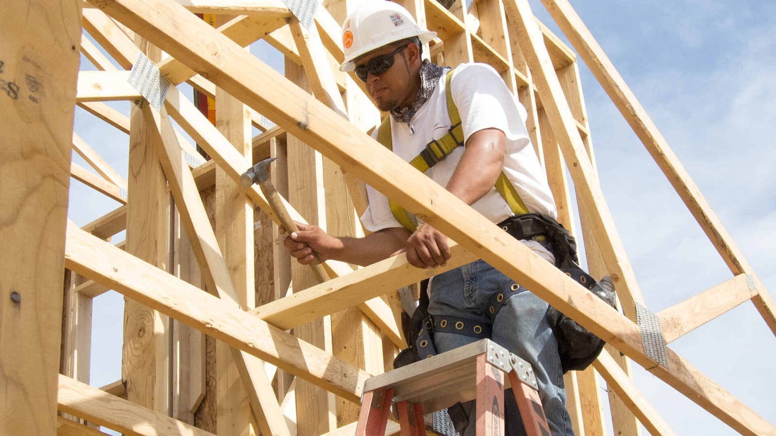 A residential construction worker using a fall arrest system