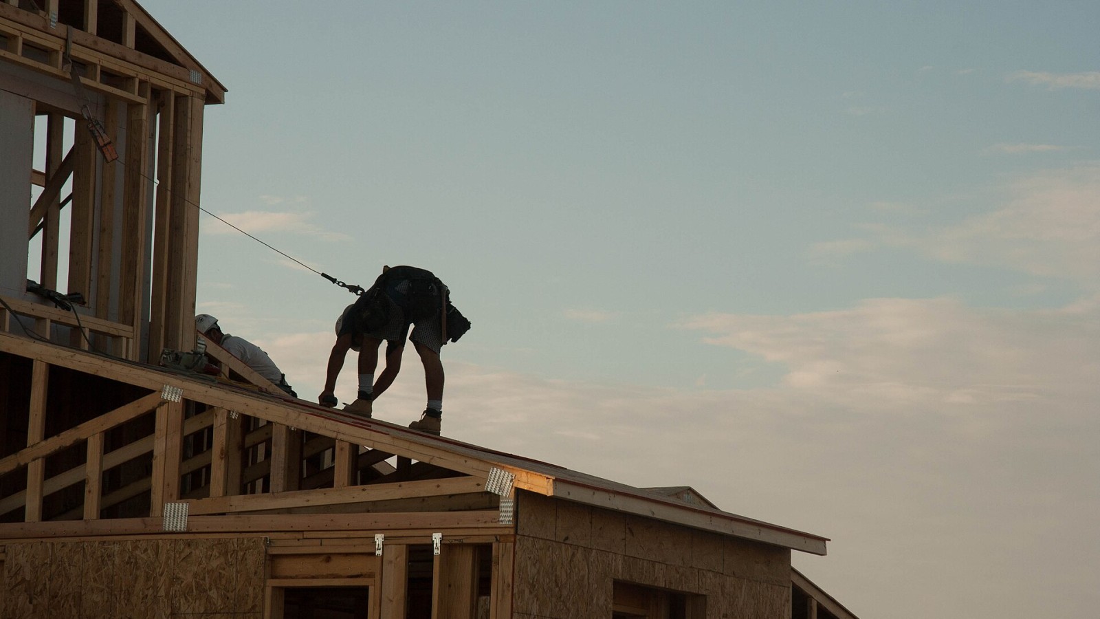 A residential construction worker using a fall prevention system