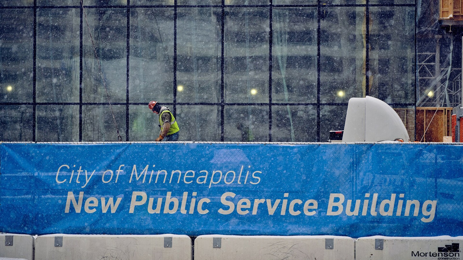 Crews work on the new City of Minneapolis Public Service Building in downtown Minneapolis, Minnesota, during a heavy snowfall on December 13, 2019.