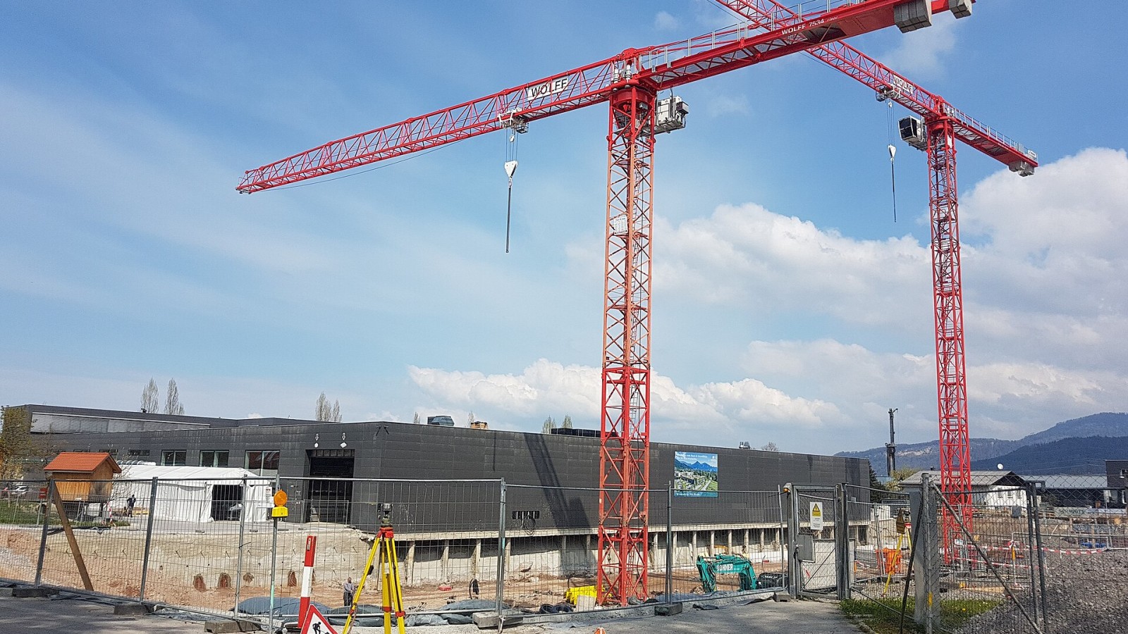 Construction site of the company Heron in Dornbirn, Vorarlberg, Austria. Construction cranes, danger and warning information, information board construction site security.