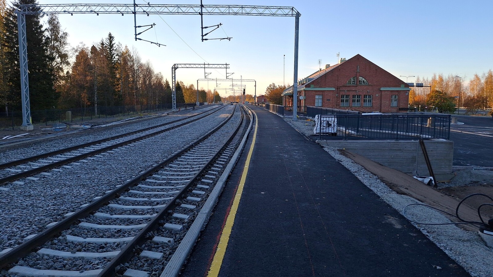 Construction works at the railway station of Tornio in Finland. A new passenger platform is being built, some new asphalt has been laid on the area, power gantries have been erected over the tracks, and so on. This is do