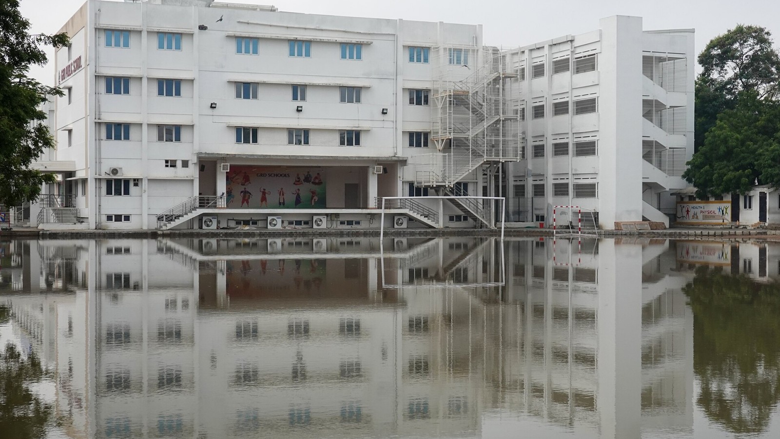 GRD Public School, reflection in flooded playing fields, view from north, Coimbatore, TN, India