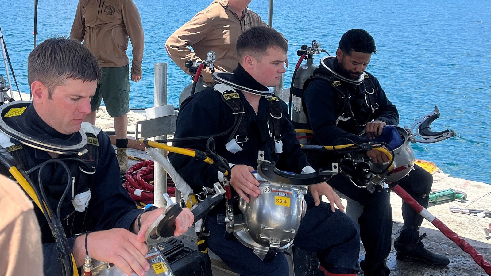 Construction Mechanic 1st Class Robert Norton, Construction Electrician 3rd Class Nicholas Bonanno, and Chief Utilitiesman Erik Martin of CTU 75.5.7 (Underwater Construction Team TWO) conduct pre-dive checks prior to ent
