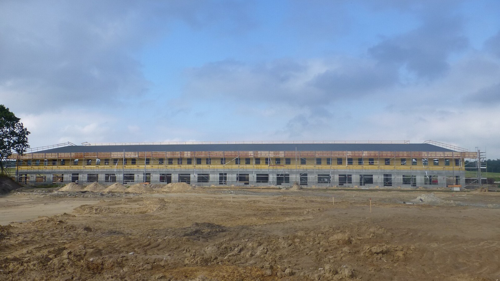 Construction of the tram depot Remise 3 at Sporvejsmuseet Skjoldenæsholm in Denmark. The left side of the depot was made to look like a row of buildings with various shops. In the foreground the ground work of the bus ex