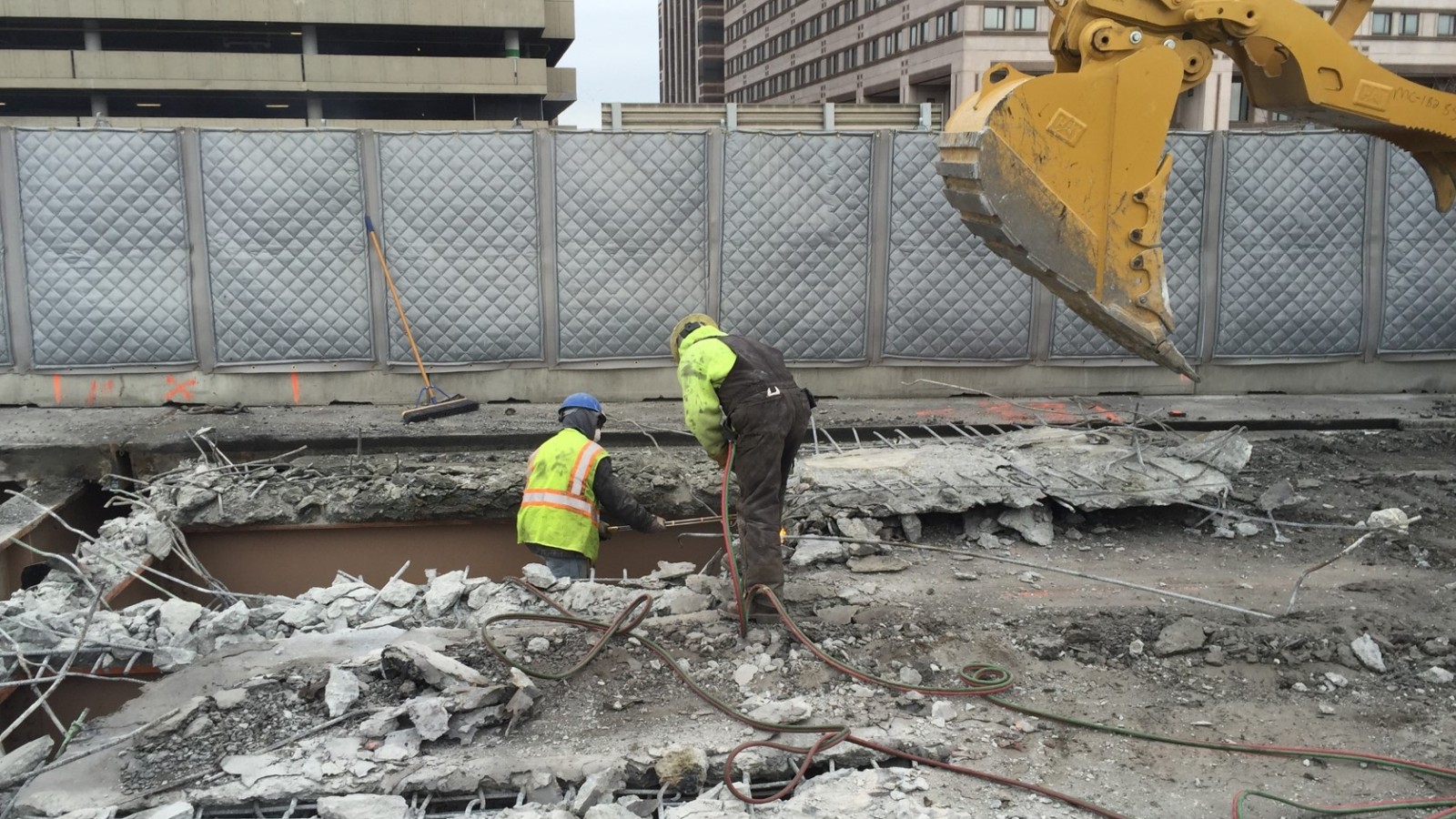 Construction workers clear away chunks of concrete as demolition of the I-91 viaduct deck begins on the inner lanes.