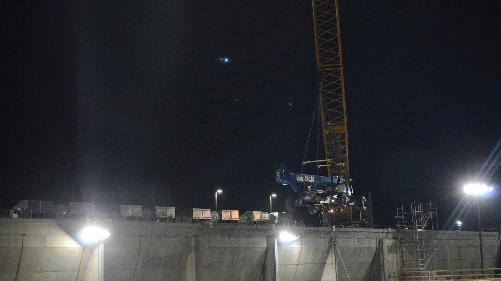 A crane raises a boom lift from the approach channel to the top of the auxiliary dam at Folsom Dam on Jan. 20, 2016. Cranes were used to pull abandoned equipment out of the approach channel after a temporary construction