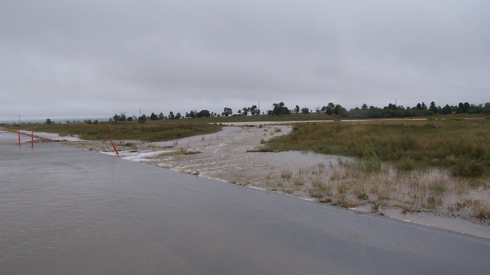 Flood waters crossing 6th Avenue looking west and south of the Legacy Trail. On Thursday, September 12, 2013, Rocky Mountain Arsenal National Wildlife Refuge experienced a dam breach at Havana Ponds located just north of