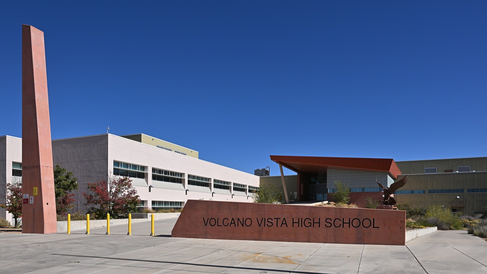 he front of Volcano Vista High School, with a sign and the main entrance behind it. Volcano Vista H.S. is part of Albuquerque Public Schools. 8100 Rainbow Road NW, Albuquerque, New Mexico 87114.