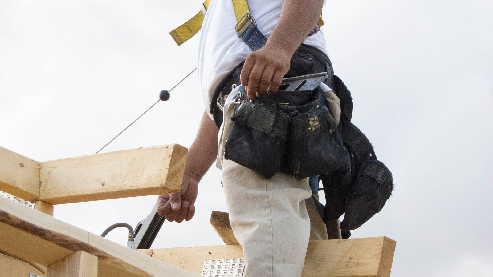 A residential construction worker uses fall prevention equipment.