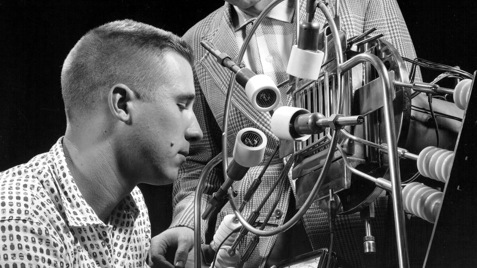Engineer and a technician checking out Ion Engine in the Electronic Propulsion Research Building at Lewis Research Center. The Ion engine uses electrostatic charge, something like pulling hot socks out of a clothes dryer