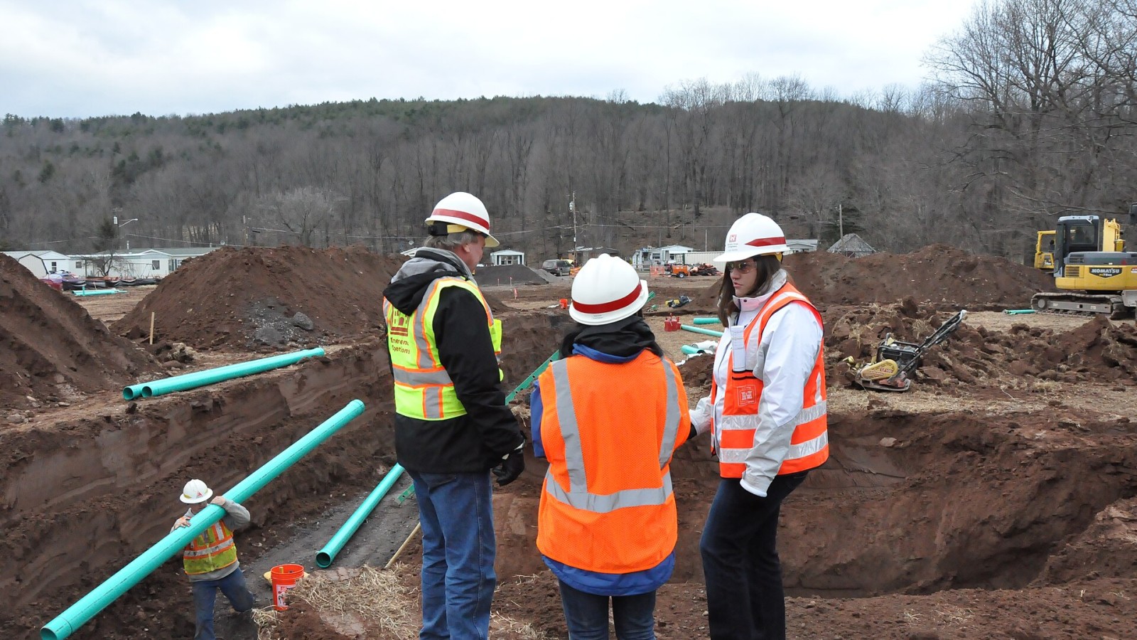Resident Engineer Don Braun (l) and Mission Manager Lucia Gamba (r) show newly arrived and soon-to-be Mission Manager Gerlyn Perlas around the temporary housing group site that is under under construction in Prattsville,