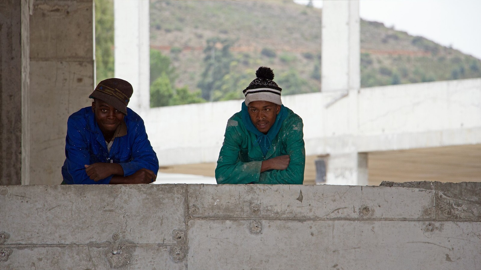 Construction workers on a building construction site in Bosman's Crossing, Stellenbosch, South Africa. Papegaaiberg is in the background.
